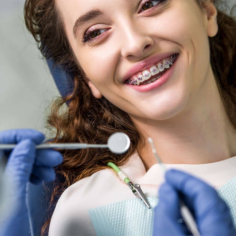 Smiling woman with braces at orthodontic appointment